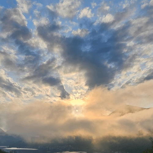 Sonne bricht durch den Morgennebel über Bergen – Symbol für Klarheit und Neubeginn.