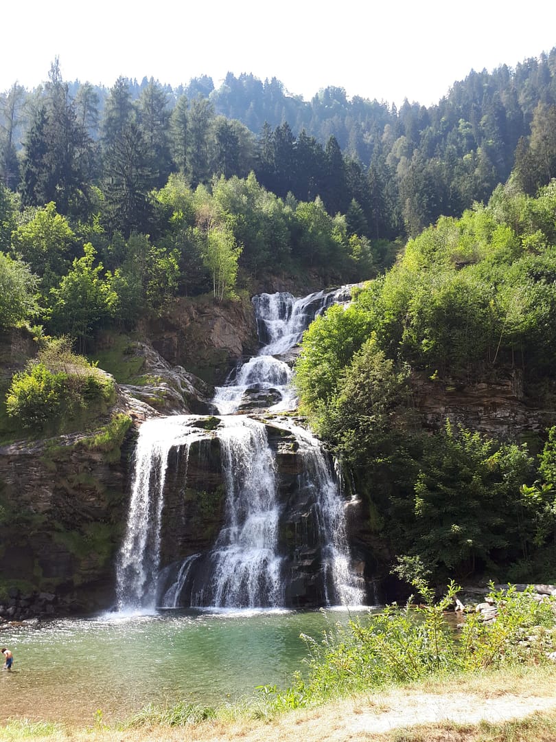 Wasserfall im Tessin – Symbol für Verbindung und Fluss Kaskadierender Wasserfall im Tessin, umgeben von grünem Wald, als Symbol für natürlichen Fluss und kraftvolle Verbindung